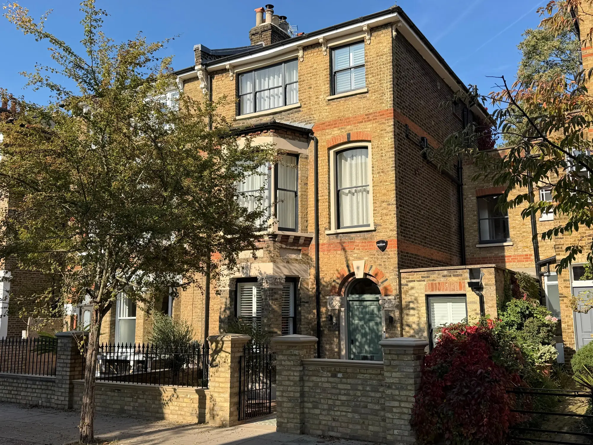 Victorian semi-detached house in Clapham in London stock brick, with a bay window, sash windows and a front garden wall and railings