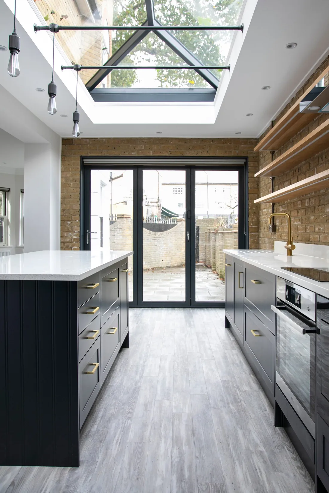 View through the kitchen to bifold doors and the garden, with the lantern rooflight overhead